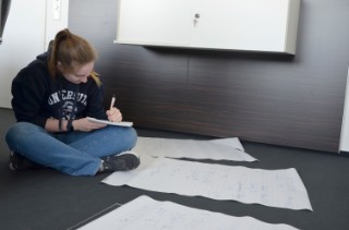 Rocket Group: Schoolgirl works cross-legged on formulas